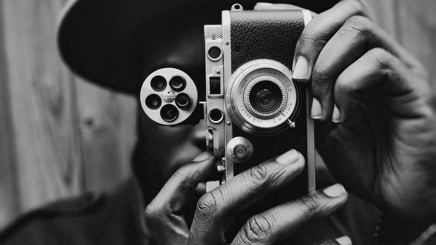 Ein Mann schießt ein Foto mit einer analogen Kamera.