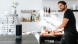 Ein Mann blickt auf seinen Smartspeaker.