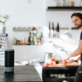 Ein Mann blickt auf seinen Smartspeaker.