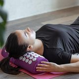 Eine Frau liegt auf einer Akupressurmatte