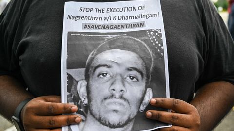 Eine Aktivistin hält ein Papier mit der Forderung "Stoppt die Hinrichtung von Nagaenthran K. Dharmalingam!"
