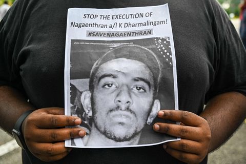 Eine Aktivistin hält ein Papier mit der Forderung "Stoppt die Hinrichtung von Nagaenthran K. Dharmalingam!"