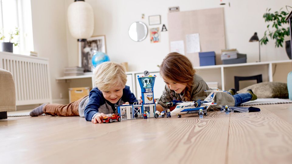 Lego Angebote: Zwei Schulkinder spielen auf dem Fußboden mit einem Lego-City-Set