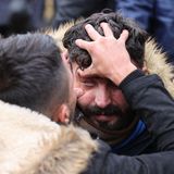 Ein Mann öffnet mit seinen Daumen das rechte Augenlid eines anderen Mannes und untersucht das Auge