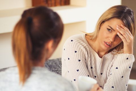 Zwei Freundinnen sitzen auf der Couch und sprechen über ihre Freundschaft