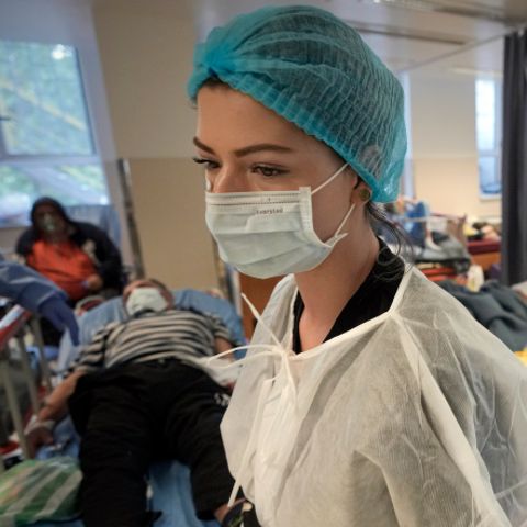 Eine Krankenschwester geht durch eine überfüllten Corona-Isolationsstation