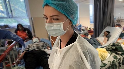 Eine Krankenschwester geht durch eine überfüllten Corona-Isolationsstation