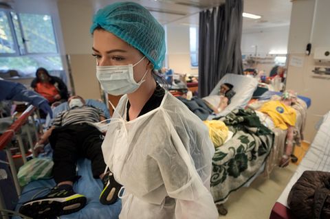 Eine Krankenschwester geht durch eine überfüllten Corona-Isolationsstation
