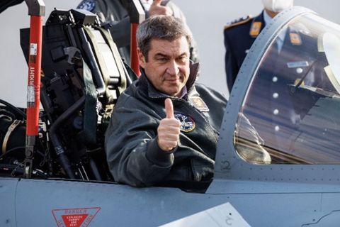 Markus Söder macht eine "Daumen-Hoch"-Geste aus dem Cockpit eines Eurofighter-Jets hinaus.