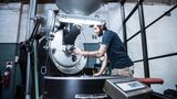 Besonders schonend geröstet  Während des Röstens erlebt die Kaffeebohne die wichtigsten Minuten in ihrem Leben. Das Aroma entsteht. Wie fein der Geschmack in der Tasse ist, hängt maßgeblich von der Art der Röstung ab. Bei der schonenden Röstung werden die Bohnen bei 150 bis 200 Grad langsam erhitzt. Zunächst entweicht das Wasser, manchmal als kleine Wölkchen sichtbar. Es duftet nach Heu. Der steigende Innendruck bläht die Bohnen auf das Doppelte ihrer Größe auf. Ihre Farbe wechselt von grün zu gelb und geht mit zunehmender Röstdauer in die typischen Brauntöne über. Ein Knacken ist zu hören, der sogenannte First Crack. Knackt es ein paar Minuten später ein zweites Mal, hat die Bohne einen mittelbrauen Röstgrad erreicht, wie er typisch für den deutschen Filterkaffee ist. Nach dem "Second Crack" laufen die chemischen Reaktionen in den etwa 400.000 Zellen einer Bohne auf Hochtouren. Der Meister muss nun die Röstung zügig beenden, da sich binnen weniger Sekunden der Geschmack immer weiter verändert. Die langsame und damit schonende Zubereitung war lange Zeit üblich. Da die Großröster immer mehr Kaffee produzieren mussten, führten die meisten das Schockrösten ein - mit den entsprechenden Einbußen in der Qualität. Statt 20 Minuten langsam bei 200 Grad zu rösten, erledigen Umluftmaschinen diese Arbeit in zwei Minuten bei 500 bis 600 Grad.