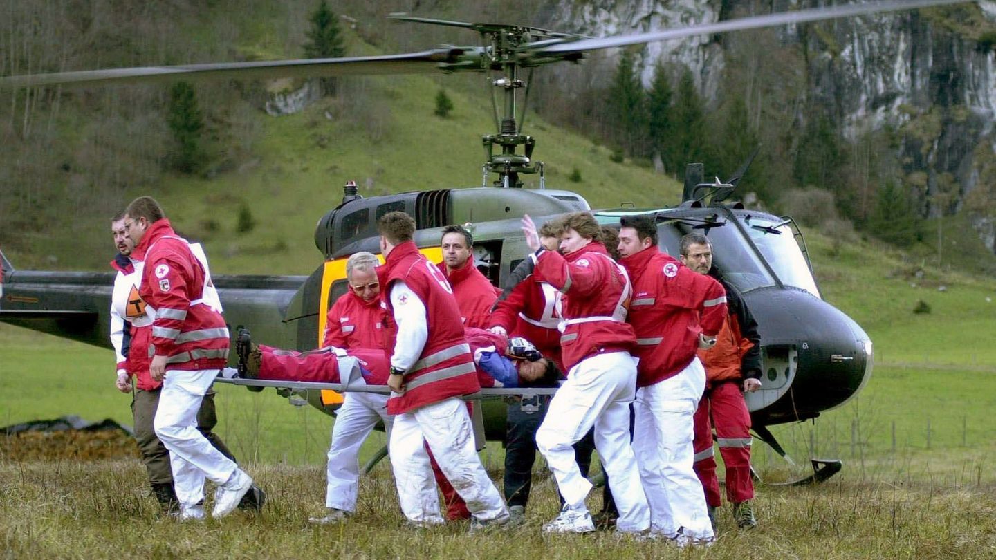 Rettungskräfte tragen einen Überlebenden zu einem wartenden Krankenwagen