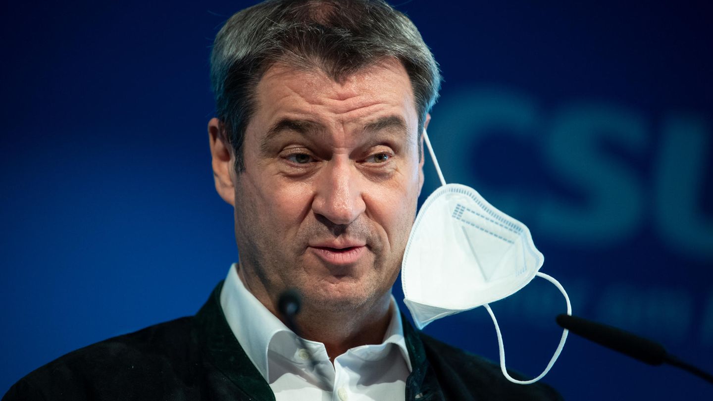 Markus Söder mit halb aufgesetzter FFP-2-Maske
