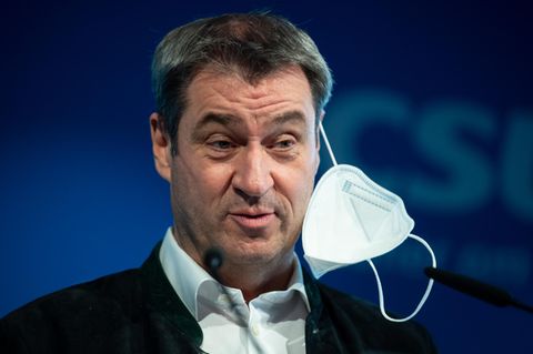 Markus Söder mit halb aufgesetzter FFP-2-Maske