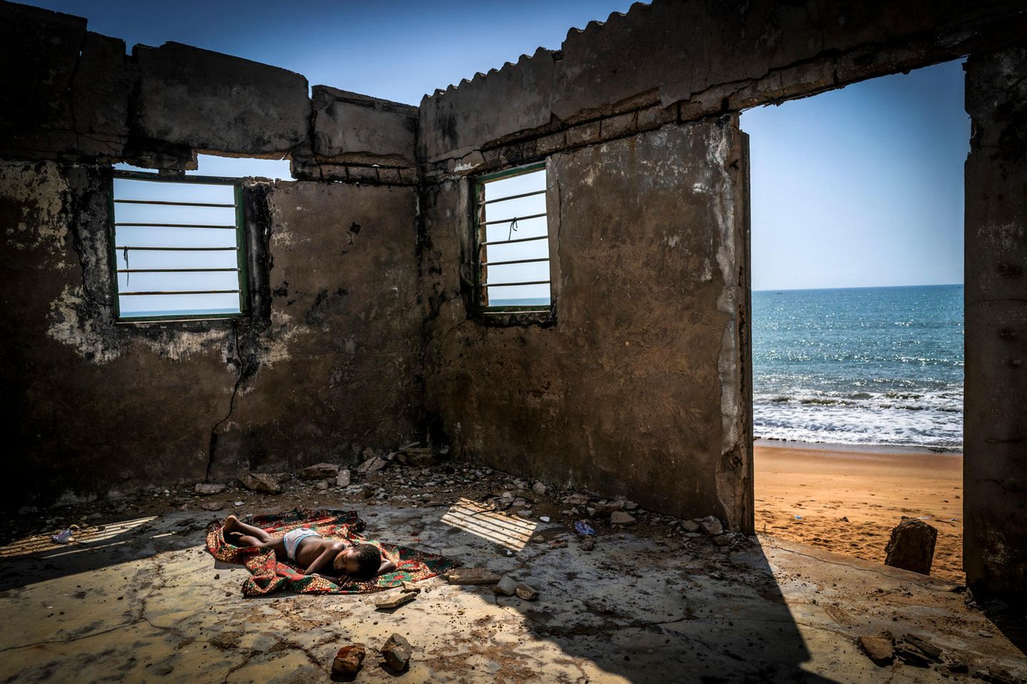 "Environmental Photographer of the Year": Antonio Aragón Renuncio Den Hauptpreis gewann der spanische Fotograf Antonio Aragón Renuncio mit seinem Bild "The Rising Tide Sons" (Die Söhne der ansteigenden Flut). Das Foto zeigt einen Jungen, der schlafend auf dem Boden seines zerstörten Hauses liegt. Das Haus liegt am Strand von Afiadenyigbaurde in Ghana und wurde von Küstenerosionen fast gänzlich zerstört. Renuncios Foto weist auf die ansteigenden Meeresspiegel hin, deren Folgen westafrikanische Länder wie Ghana immer mehr zu spüren bekommen. Tausende Menschen wurden dort bereits gezwungen, ihre Häuser zu verlassen.