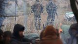 Polnisches Militär behält die Geflüchteten hinter dem Stacheldrahtzaun auf belarussischer Seite der Grenze im Auge.