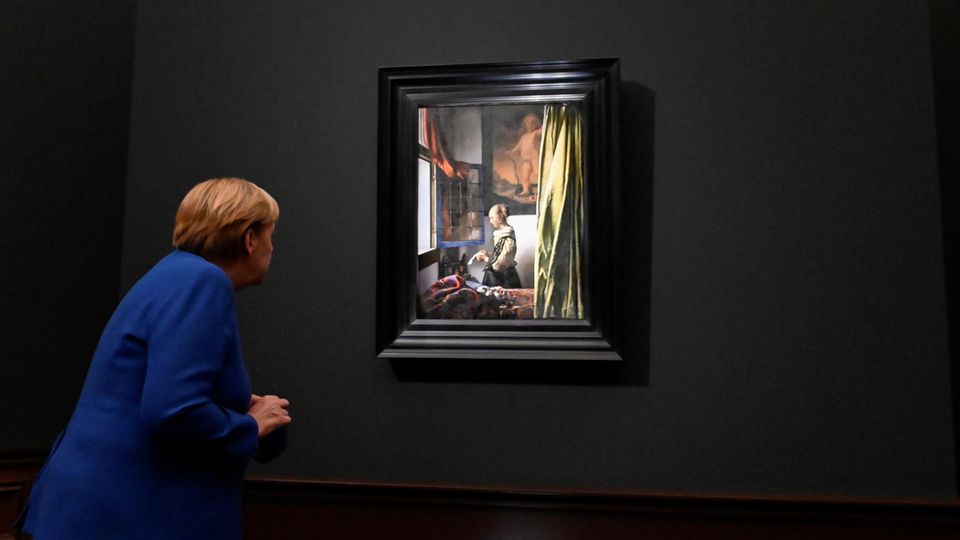Johannes Vermeer Google Doodle Jan Vermeer Kanzlerin Merkel beugt sich zu einem Gemälde und betrachtet es genau