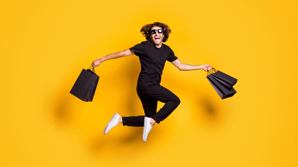 Frühe Black Friday Angebote auf Amazon: Ein in schwarz gekleideter Mann springt vor Freude in die Luft.