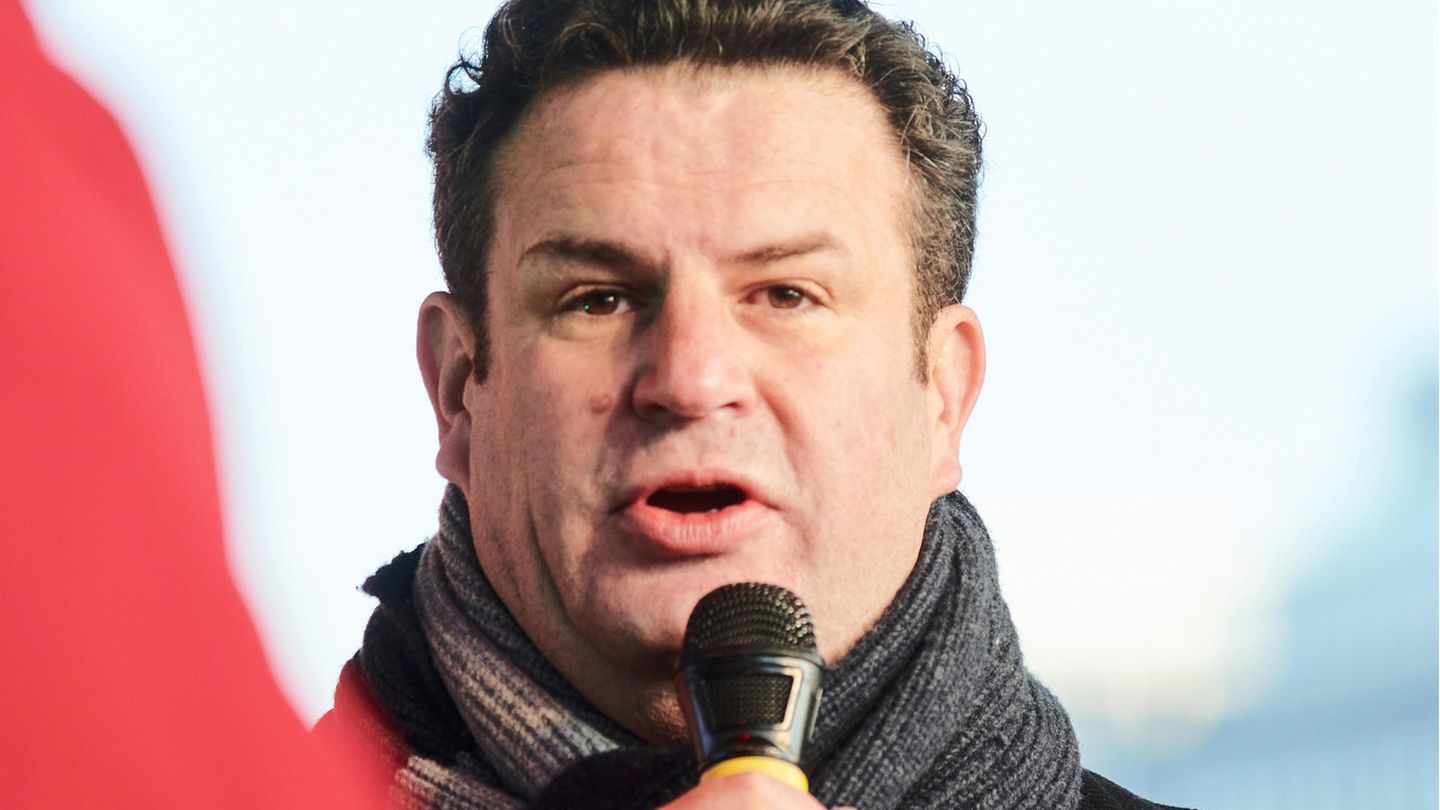 Hubertus Heil spricht in ein Mikrofon und trägt einen Wollschal