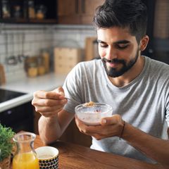 Ein Mann löffelt Quark aus einer Schale