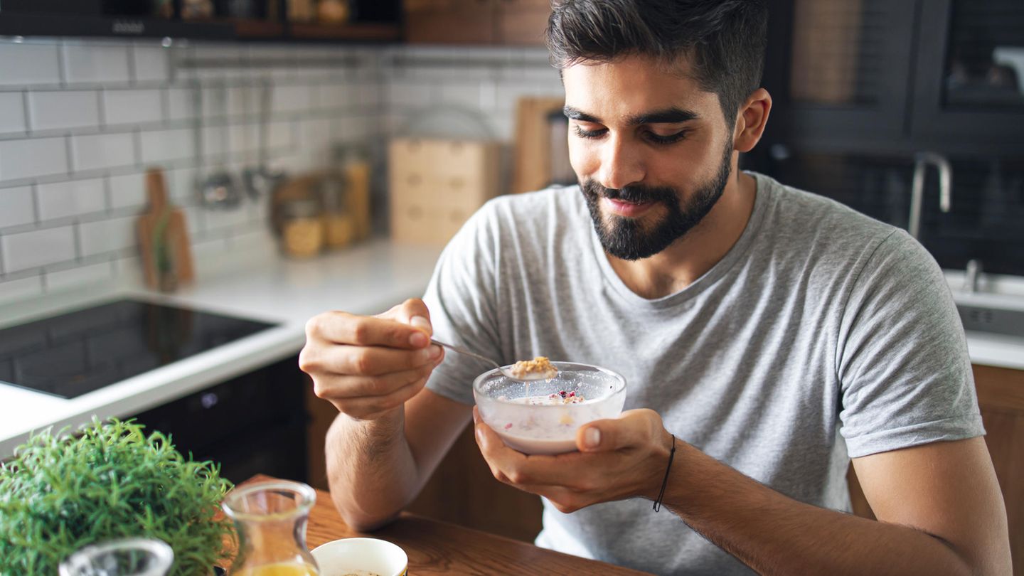 Ein Mann löffelt Quark aus einer Schale