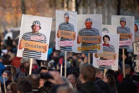 Plakate zeigen Drosten, Söder und Lauterbach in Gefangenenkluft und tragen die Unterschrift "schuldig"