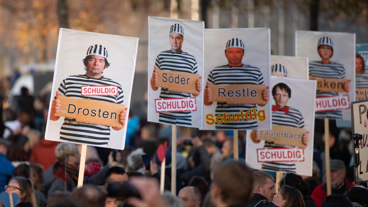 Plakate zeigen Drosten, Söder und Lauterbach in Gefangenenkluft und tragen die Unterschrift "schuldig"
