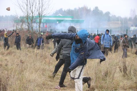 Ein Mann wirft einen Stein in Richtung Grenze