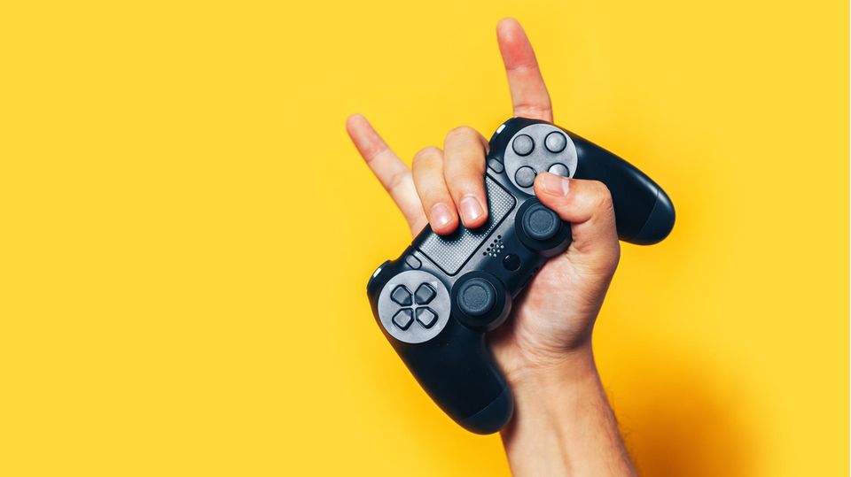 Geschenke für Gamer: Eine Hand hält einen PS4-Controller.