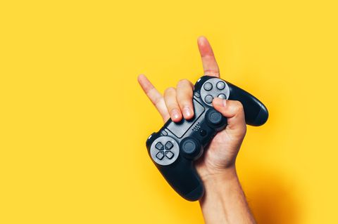 Geschenke für Gamer: Eine Hand hält einen PS4-Controller.