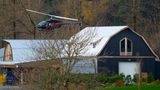 Ein Hubschrauber startet von einer Farm, die von Hochwasser umgeben ist.