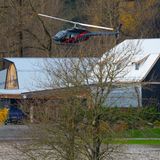 Ein Hubschrauber startet von einer Farm, die von Hochwasser umgeben ist.