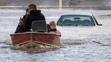 Menschen die durch das Hochwasser gestrandet sind, werden von Freiwilligen in einem Boot gerettet.