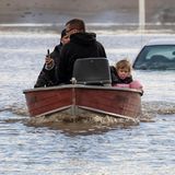Menschen die durch das Hochwasser gestrandet sind, werden von Freiwilligen in einem Boot gerettet.