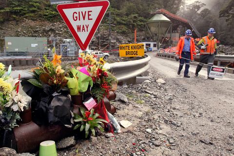 Arbeiter gehen an Blumen für die Opfer der Minenexplosion in der Pike-River-Mine vorbei (Archivbild)