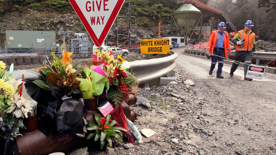 Arbeiter gehen an Blumen für die Opfer der Minenexplosion in der Pike-River-Mine vorbei (Archivbild) Arbeiter gehen an Blumen für die Opfer der Minenexplosion in der Pike-River-Mine vorbei (Archivbild)
