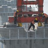 Das Team macht die "Füße" der Maschine auf den Pfeilern fest. 