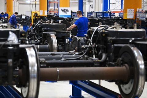 Arbeiter montieren bei der Stadler Rail Service Deutschland GmbH an Drehgestellen für Personenzüge