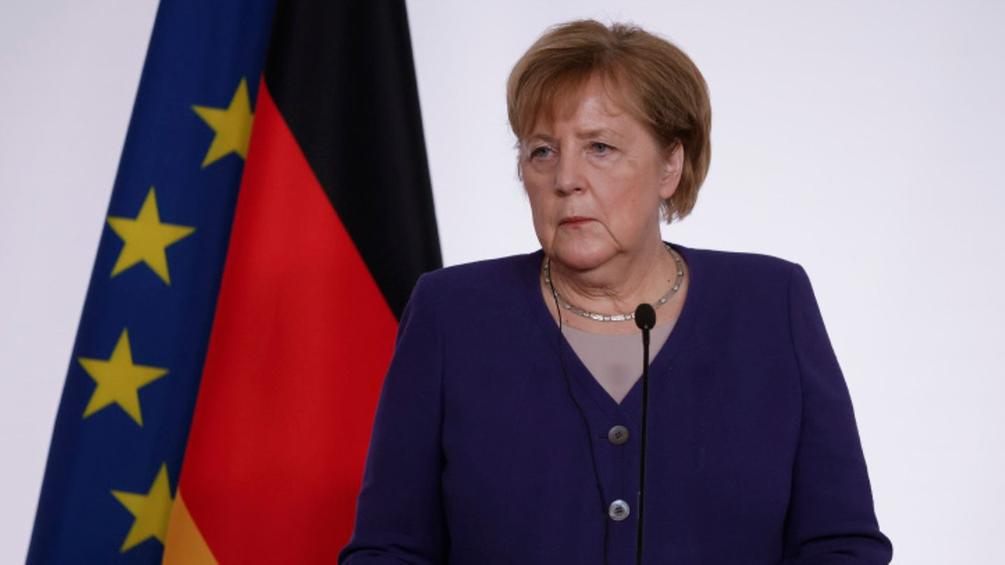 Angela Merkel (CDU) vor Deutschland- und EU-Flagge