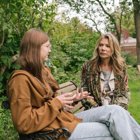 Jana sitzt im Trauma-Therapiezentrum Ankerland mit Ursula Karven im Garten