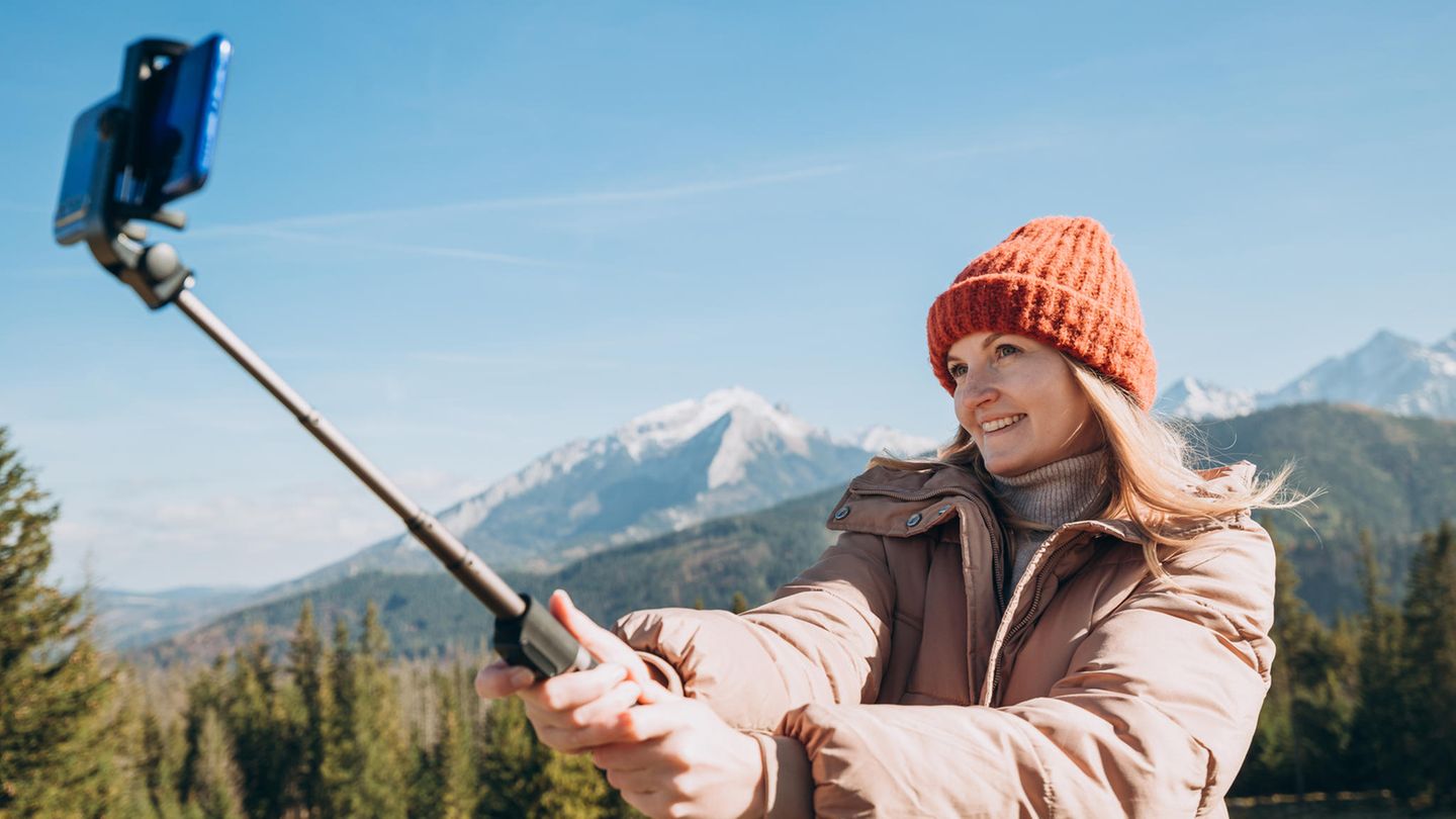 Eine Frau hält einen Selfiestick in der Hand