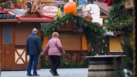 Ein Pärchen spaziert an den geschlossenen Buden des Dresdner Striezelmarktes vorbei
