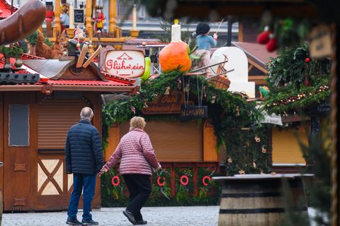 Ein Pärchen spaziert an den geschlossenen Buden des Dresdner Striezelmarktes vorbei