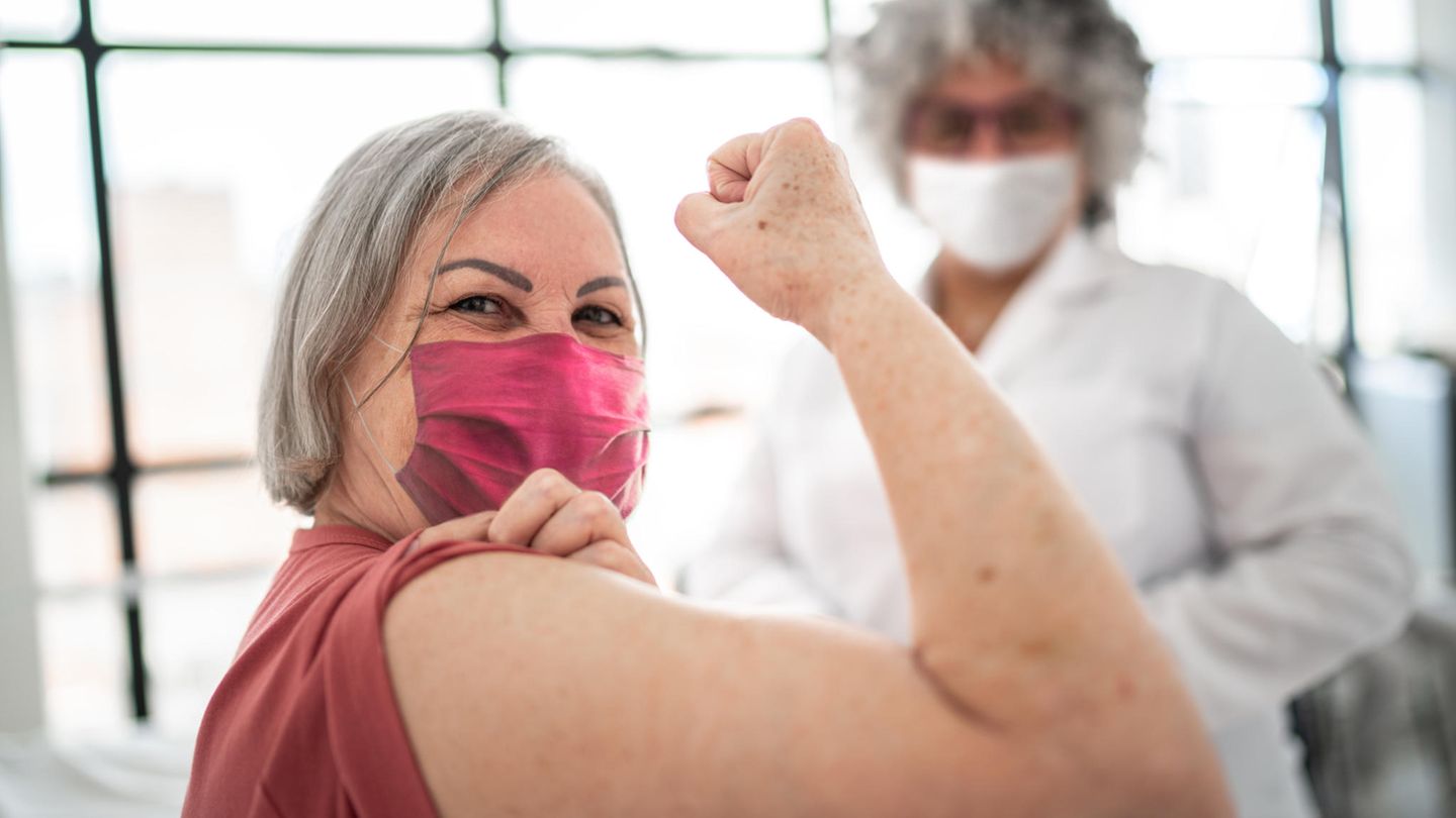 Frau hält stolz ihren geimpften Arm in die Kamera