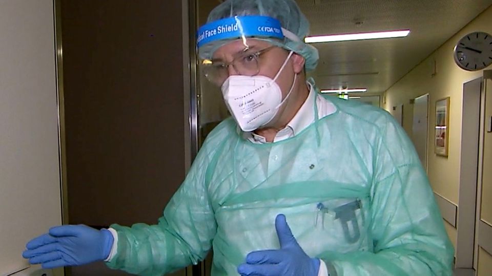 Corona-Medikament: Dieses Mittel schützt nach einer Infektion vor schwerem Verlauf Ein Arzt in Schutzkleidung steht in einem Krankenhausflur.