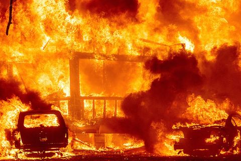 Ein Feuer lodert heftig an einem Haus.