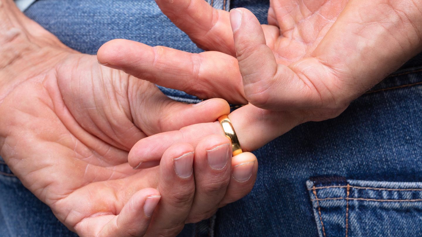 Mann zieht sich den Ehering vom Finger