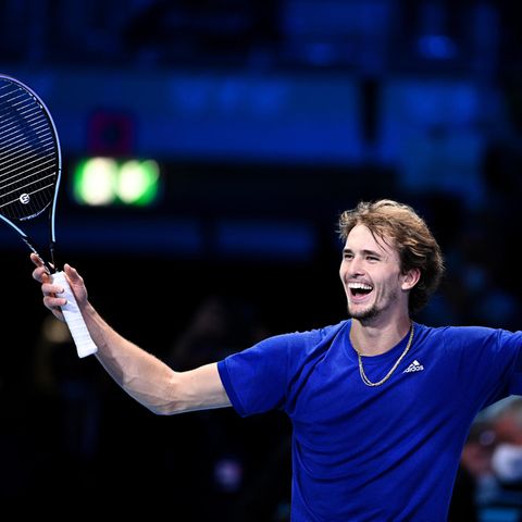 Lachender Alexander Zverev mit erhobenen Händen und Tennisschläger