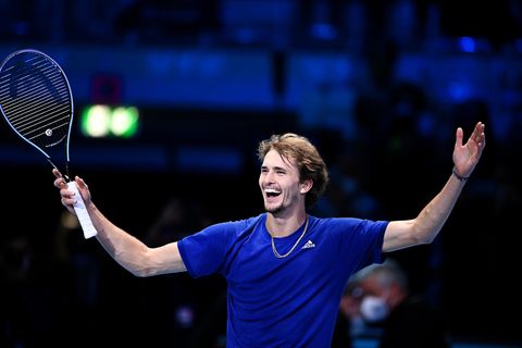 Lachender Alexander Zverev mit erhobenen Händen und Tennisschläger