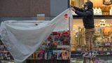 Wien, Österreich. Ein Verkäufer deckt einen Kiosk in einer Einkaufsstraße mit einer Plastikfolie ab.