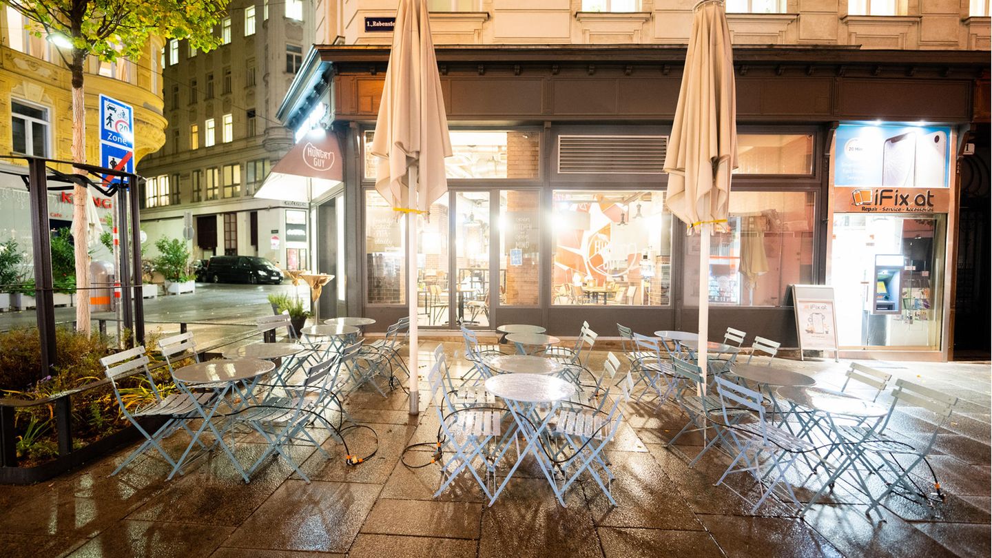 Wien, Österreich. Leere Tische und Stühle stehen vor einem Restaurant.